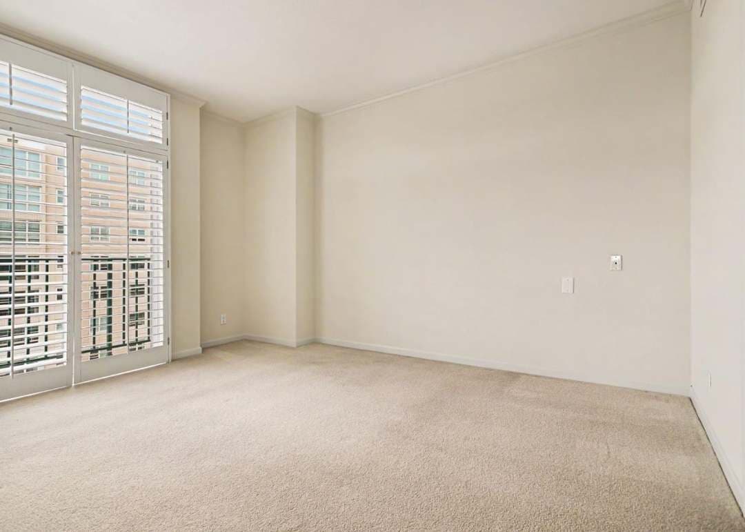 Condo bedroom with large windows, carpet and unfurnished