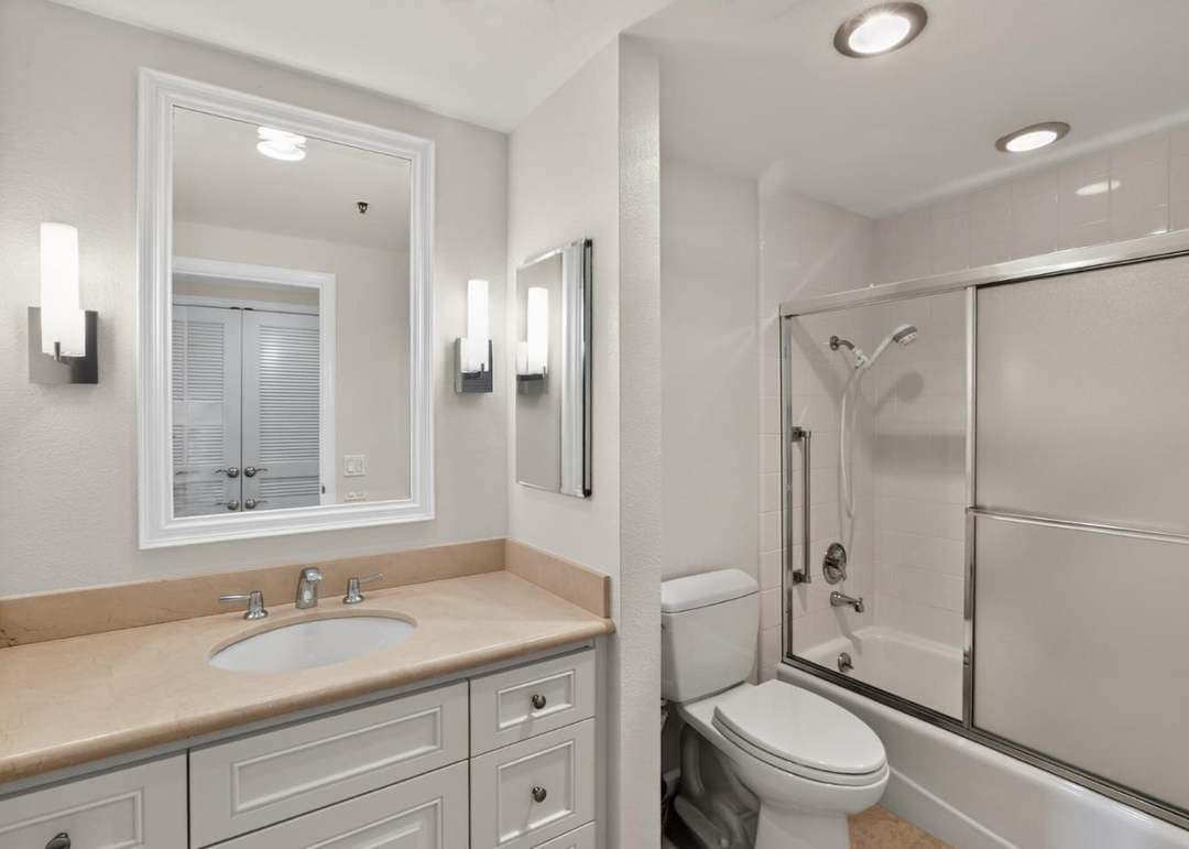 Bathroom with shower and white vanity cabinetry